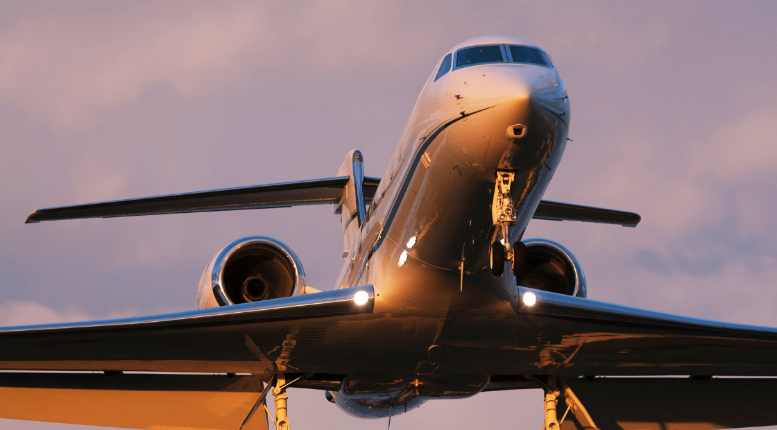 Private business jet taking off at dusk