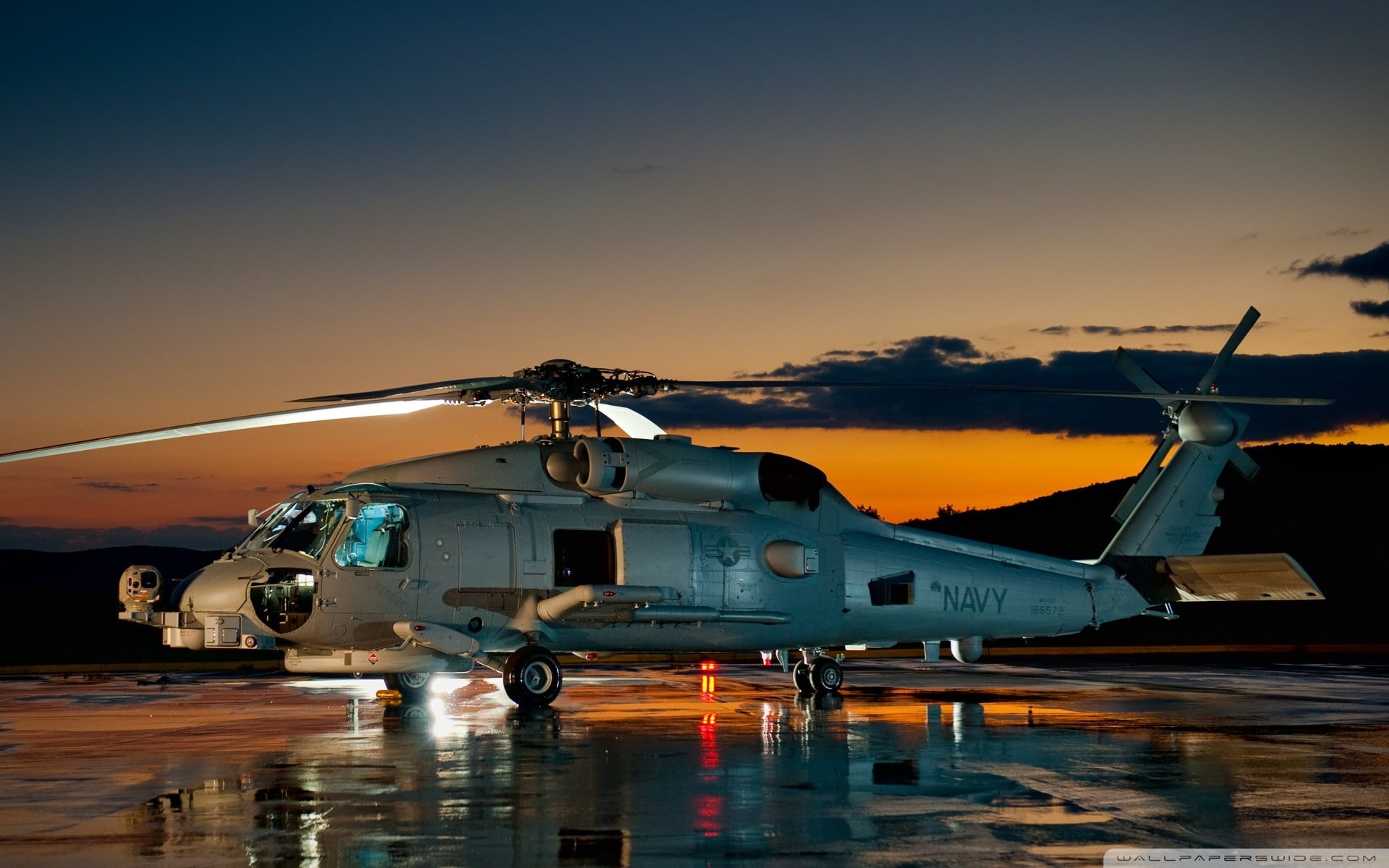 Military Navy helicopter on a tarmac at sunset